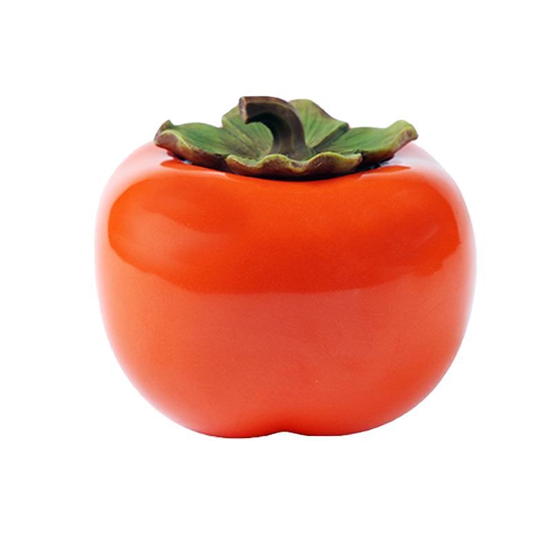 Small orange ceramic persimmon tea jar with a leaf shaped lid