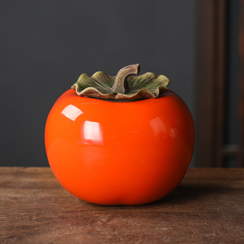 Large orange ceramic persimmon tea jar with a leaf shaped lid