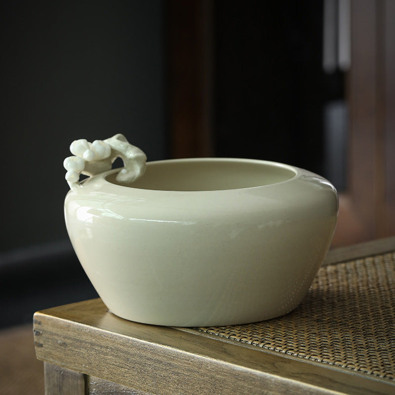 Ivory ceramic tea rinse bowl with sculpted plum blossoms on the rim