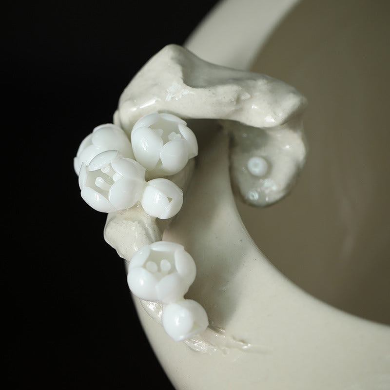 Close view of the raised ceramic plum blossoms on the bowl rim