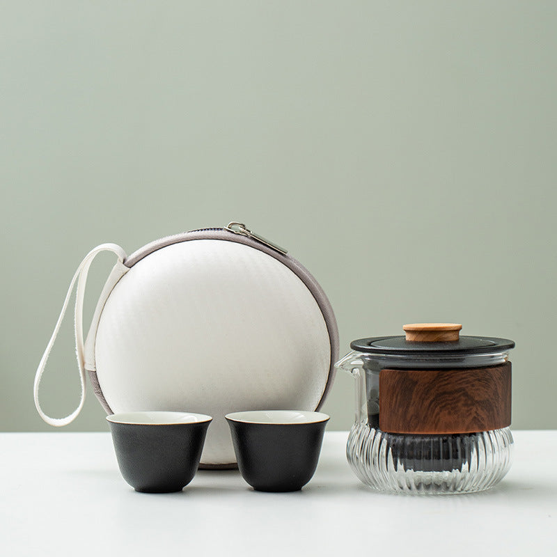 Black ceramic cups and infuser with a ribbed glass pitcher and round carry case