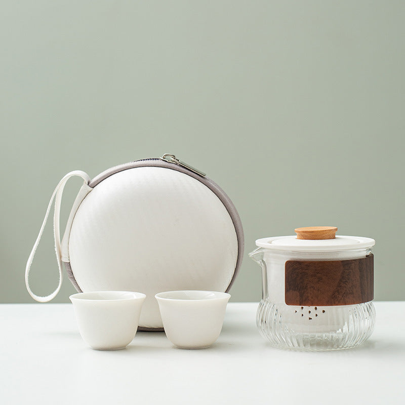 White ceramic cups and infuser with a ribbed glass pitcher and round carry case