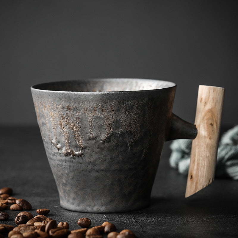 Flared Cup in dark textured ceramic with a warm metallic glaze and wooden handle