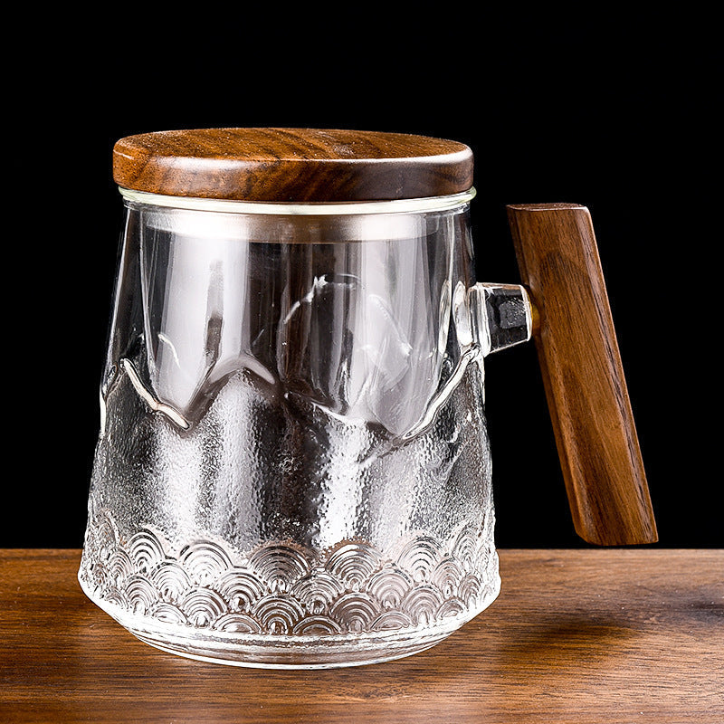 Clear glass tea mug with raised mountain and wave decoration