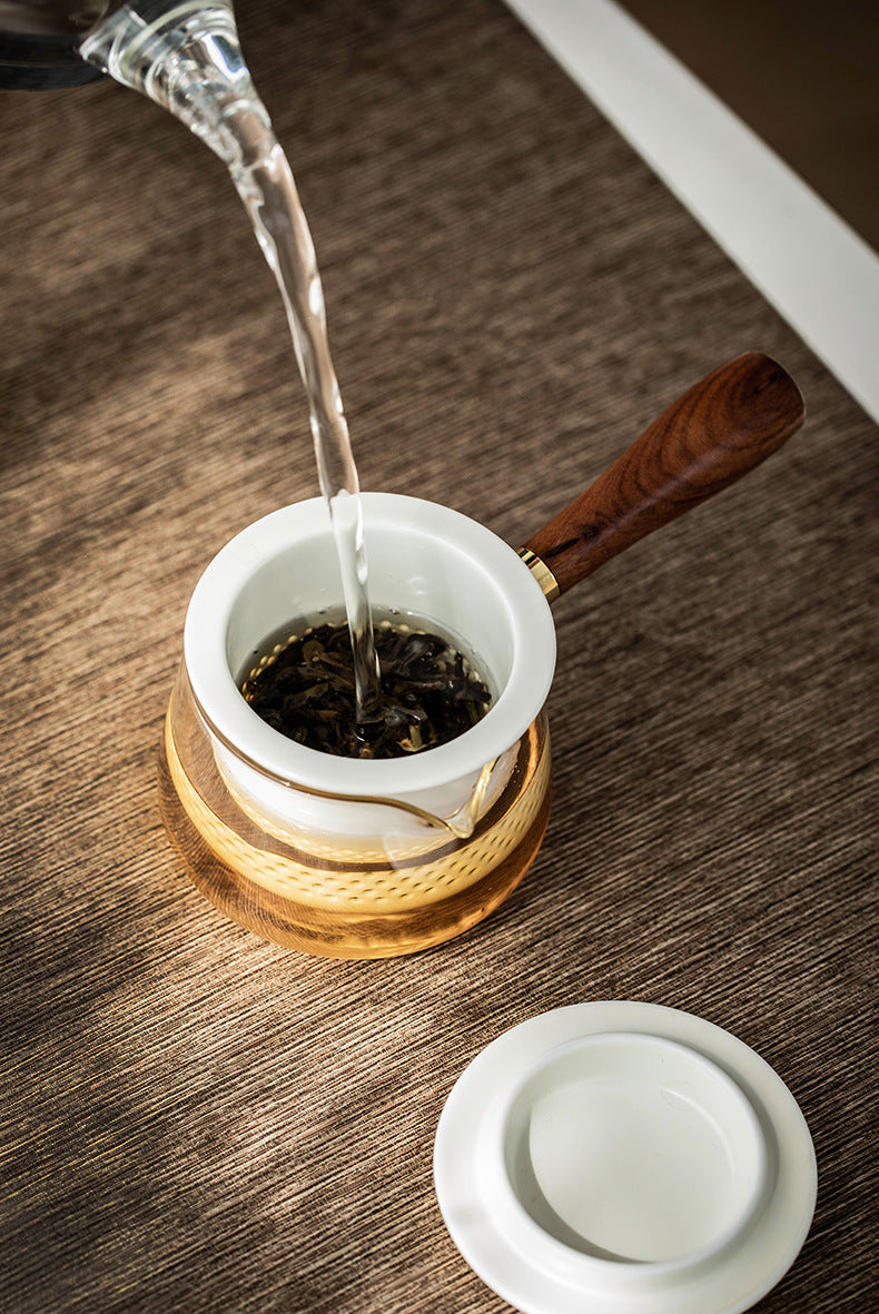 Water filling the removable white ceramic infuser inside the glass side-handle brewer