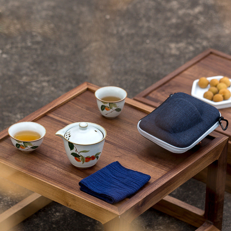 Persimmon ceramic tea set on a tray with matching cups and blue case