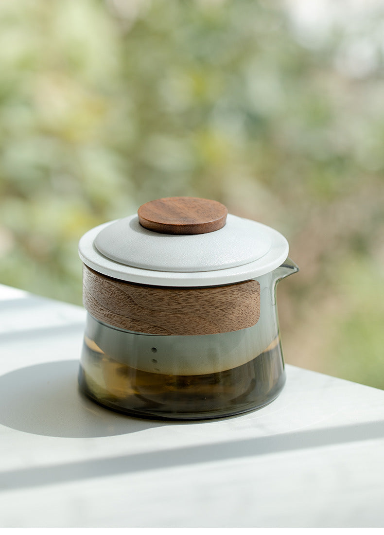 Close-up of the glass travel brewer, white ceramic lid, wooden knob and wood-look grip band