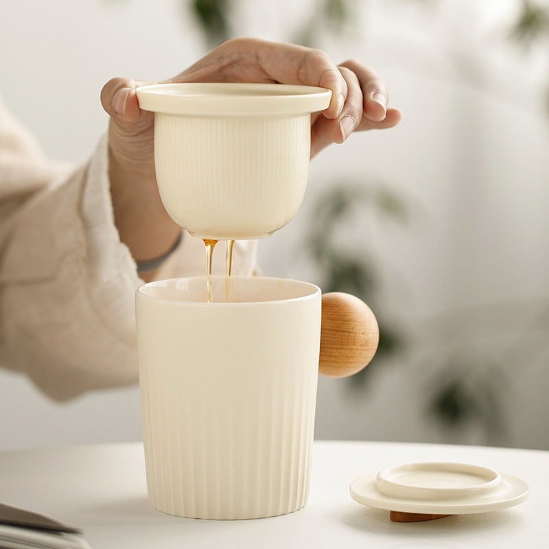 Removable ceramic tea infuser draining into the cream mug