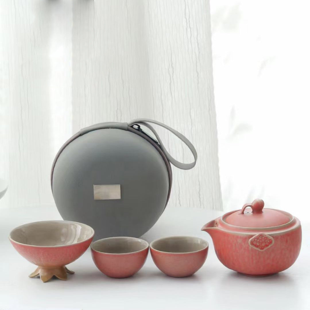 Pink pomegranate shaped ceramic tea set with two cups and a round case