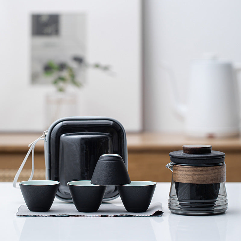 Black ceramic travel tea set with smoke-gray glass brewer, four cups and zip case