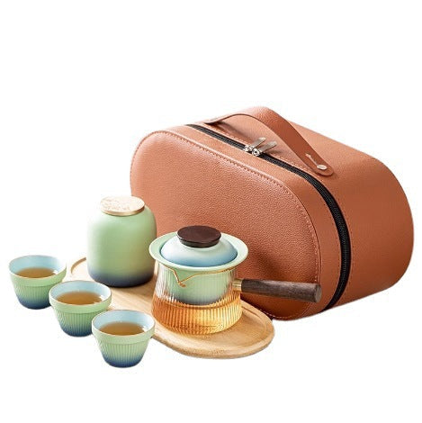 Blue gradient travel tea set with a side-handle glass brewer, three cups, jar, tray and orange case