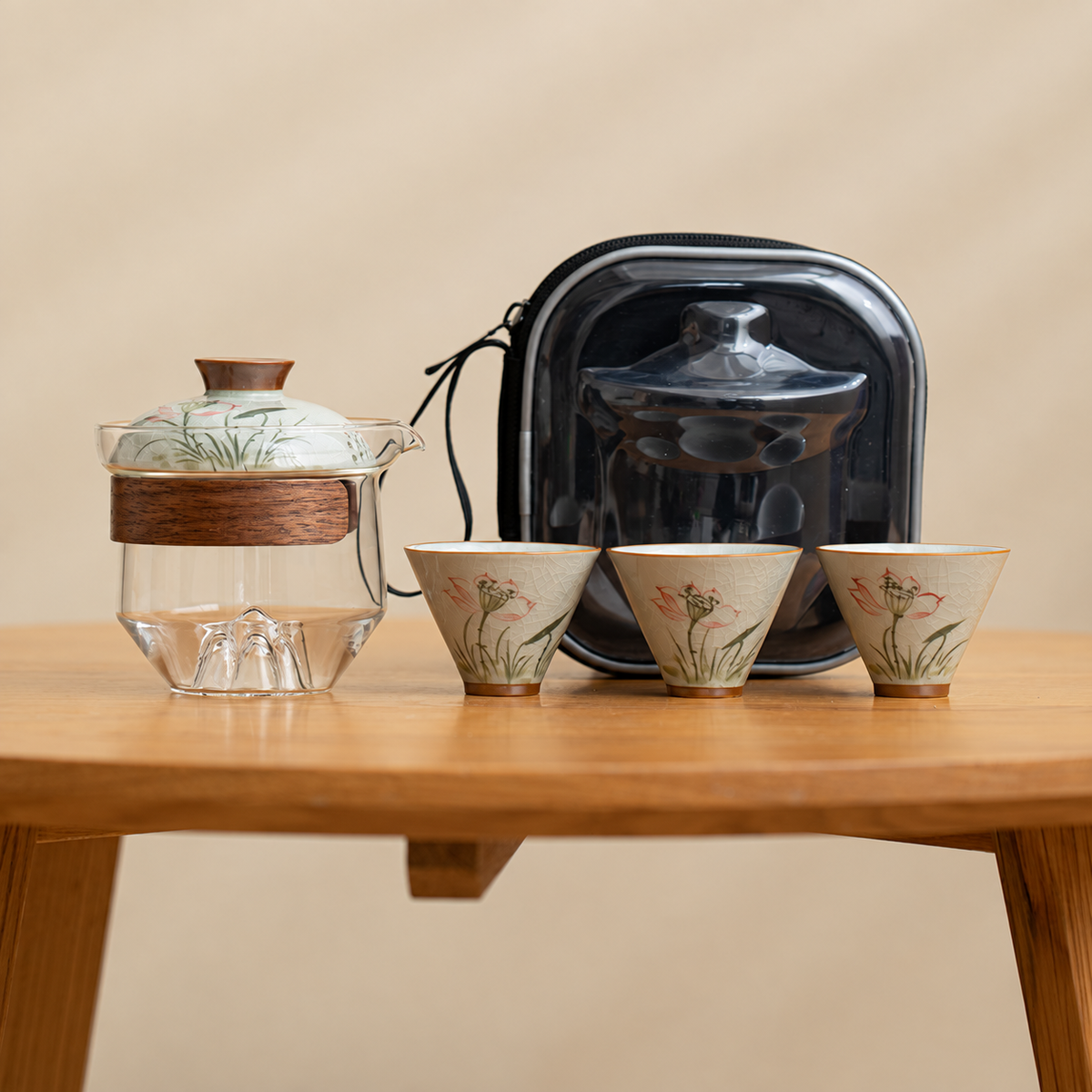 Lotus / Clear glass tea brewer with three patterned ceramic cups and a black travel case