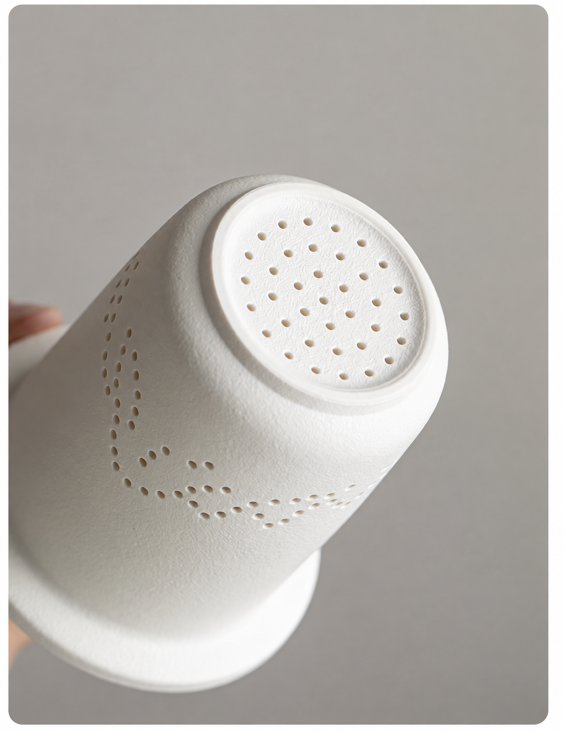 Close view of the perforations in the ceramic tea infuser