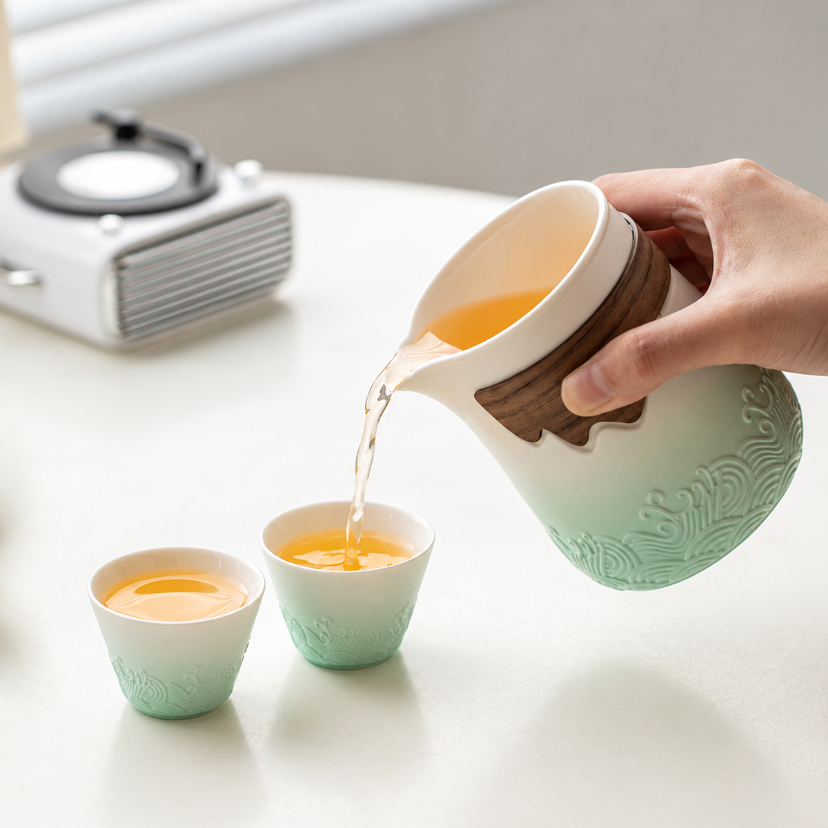 A hand pouring tea from the white and mint wave-relief brewer