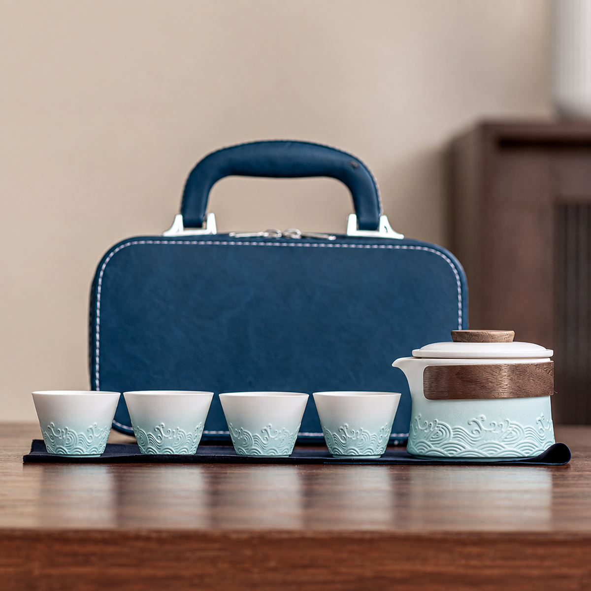 Pale blue wave-relief ceramic brewer with four cups and blue carrying case