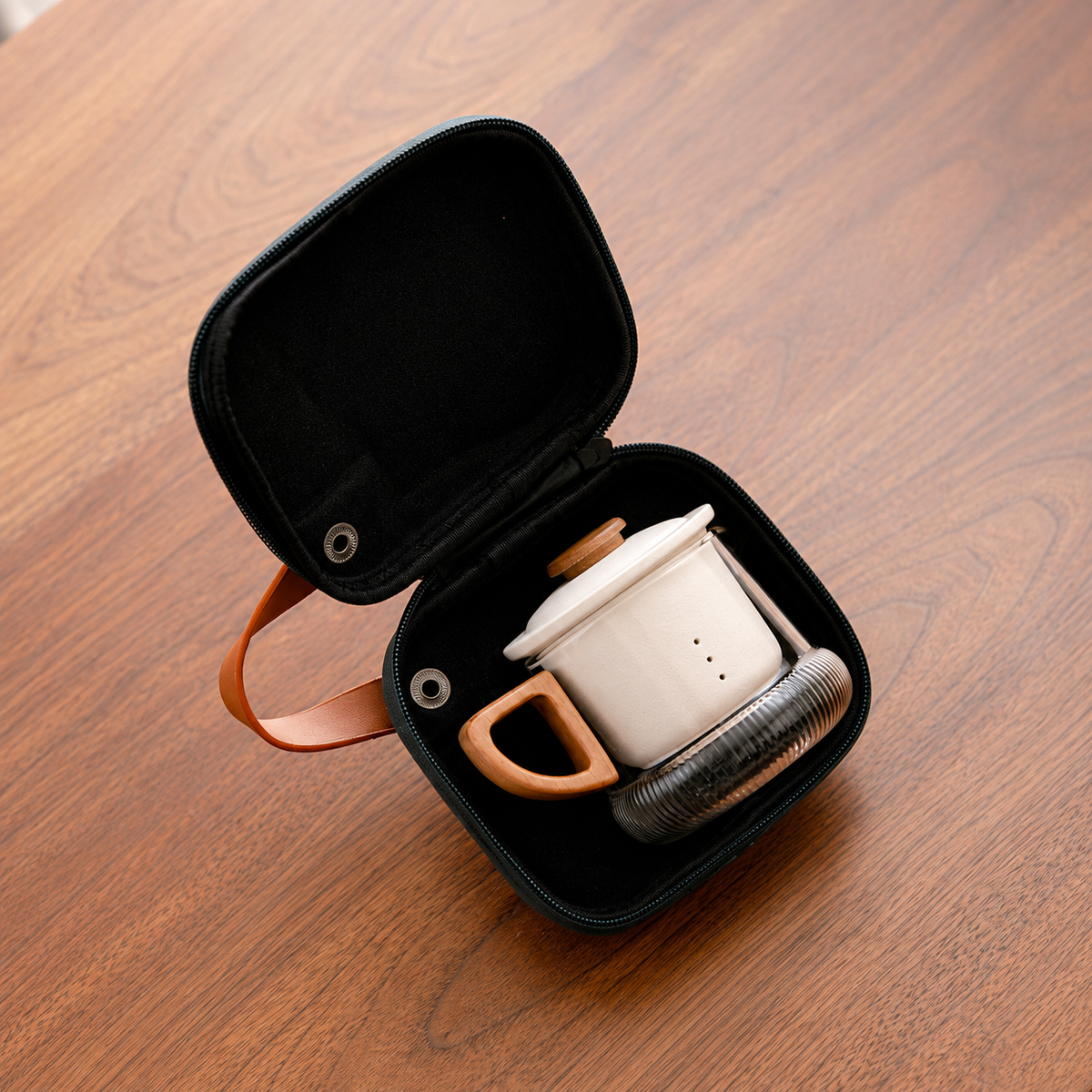 The clear glass brewer with white ceramic infuser stored inside its fitted zip case