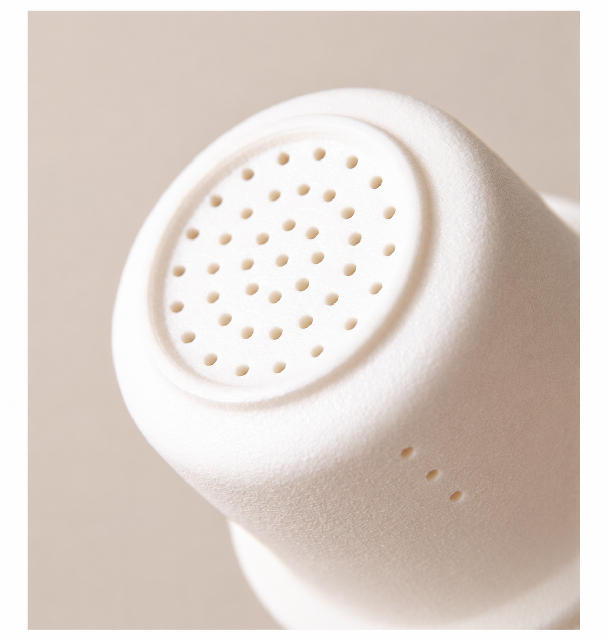 Close view of the white ceramic infuser base and three side holes