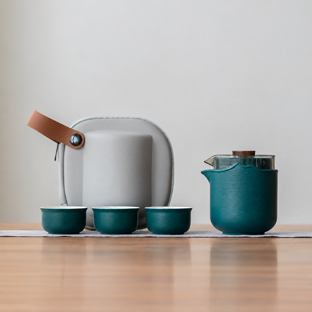 Green nested glass and ceramic travel tea set, classic configuration, with three cups and gray case