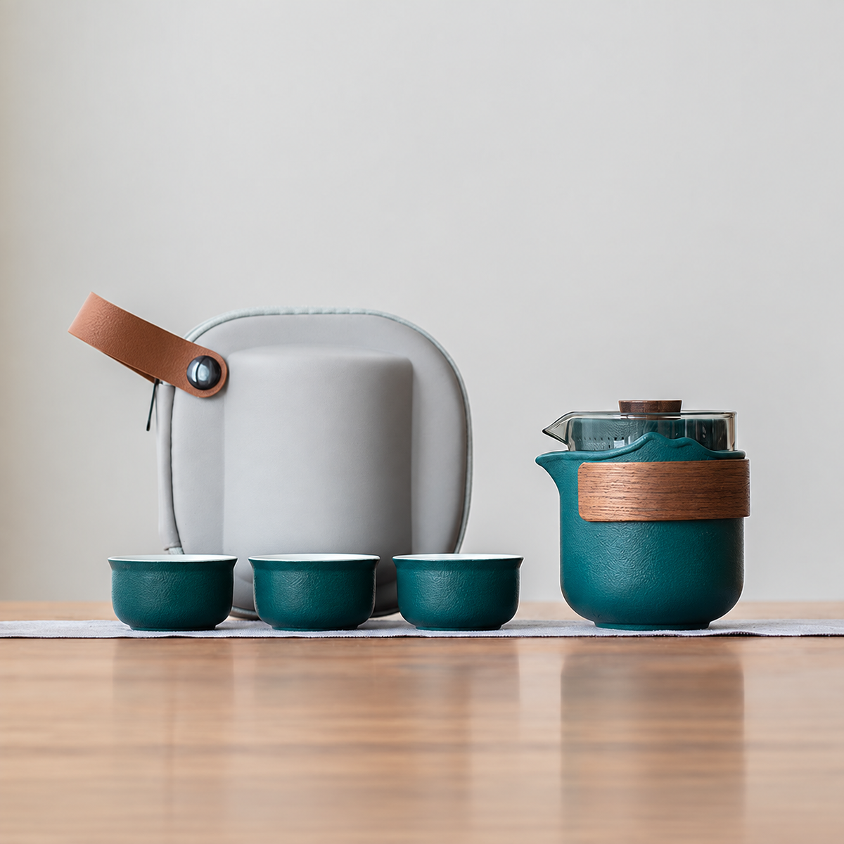 Green nested glass and ceramic travel tea set, bamboo wrap configuration, with three cups and gray case