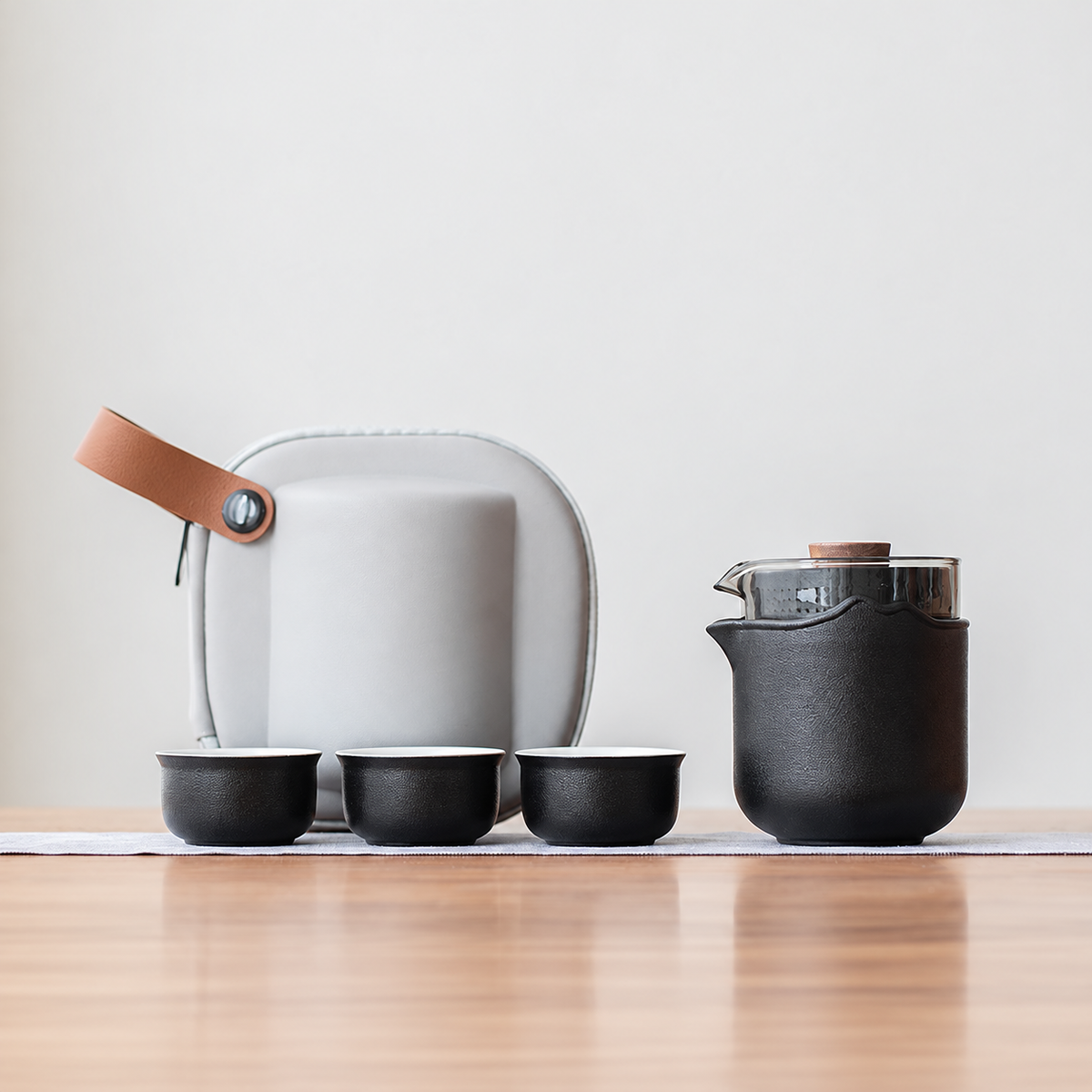 Black nested glass and ceramic travel tea set, classic configuration, with three cups and gray case