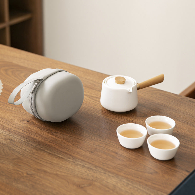 White side-handle ceramic travel tea brewer with three cups and a round zip case