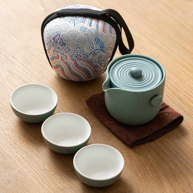 Green ceramic travel tea set with three cups and patterned case