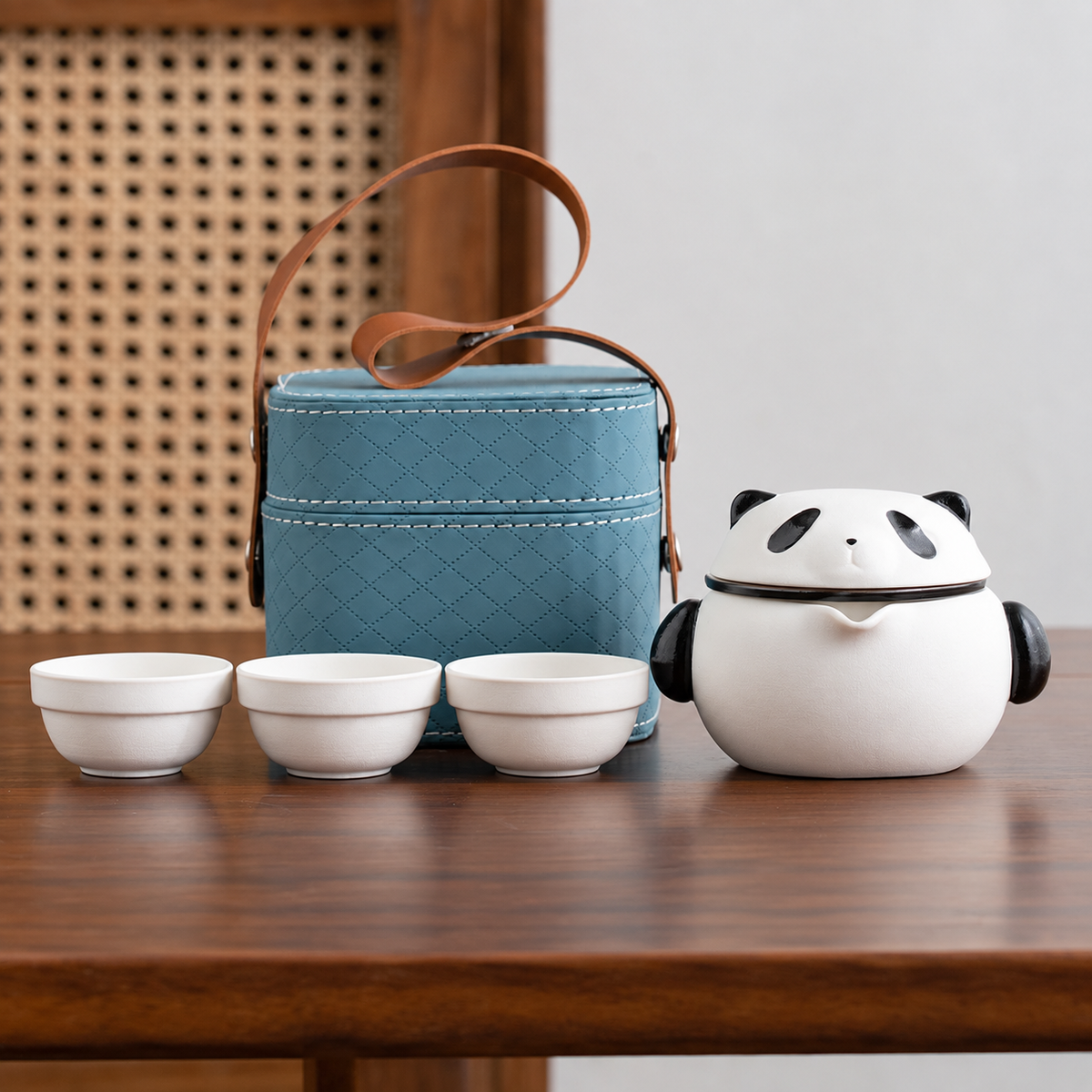 Panda ceramic tea brewer and three white cups with the quilted blue carrying case