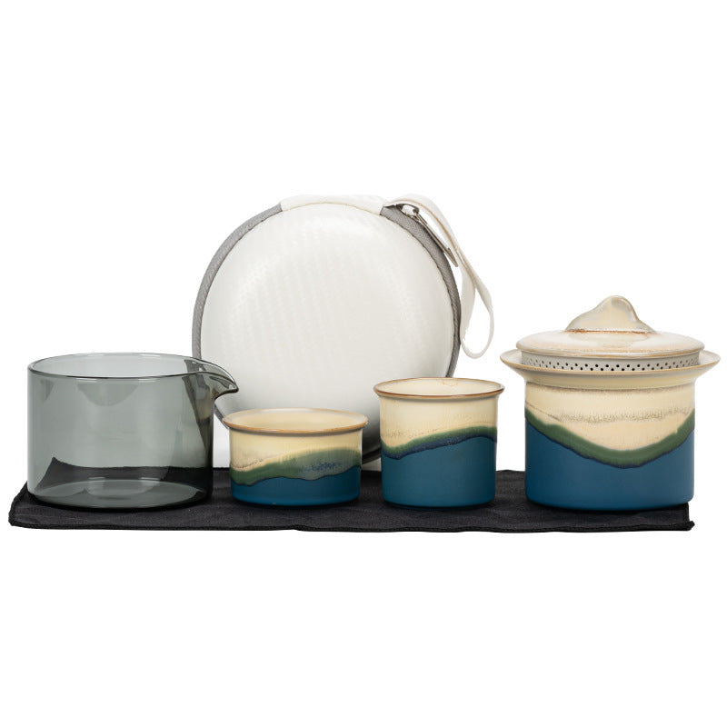 Blue landscape-glaze travel tea set with two different-size cups, glass pitcher, lidded brewer and white case