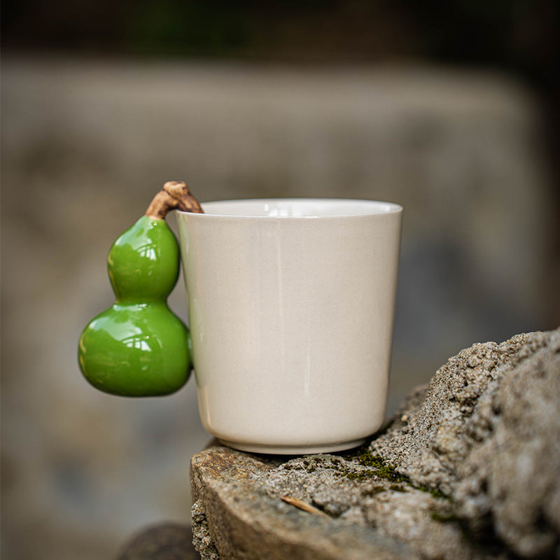 Cream gourd handle mug standing on a rock