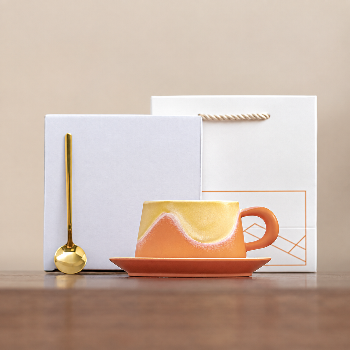 Orange wave-glaze cup and saucer with gold-tone spoon, plain box and geometric gift bag
