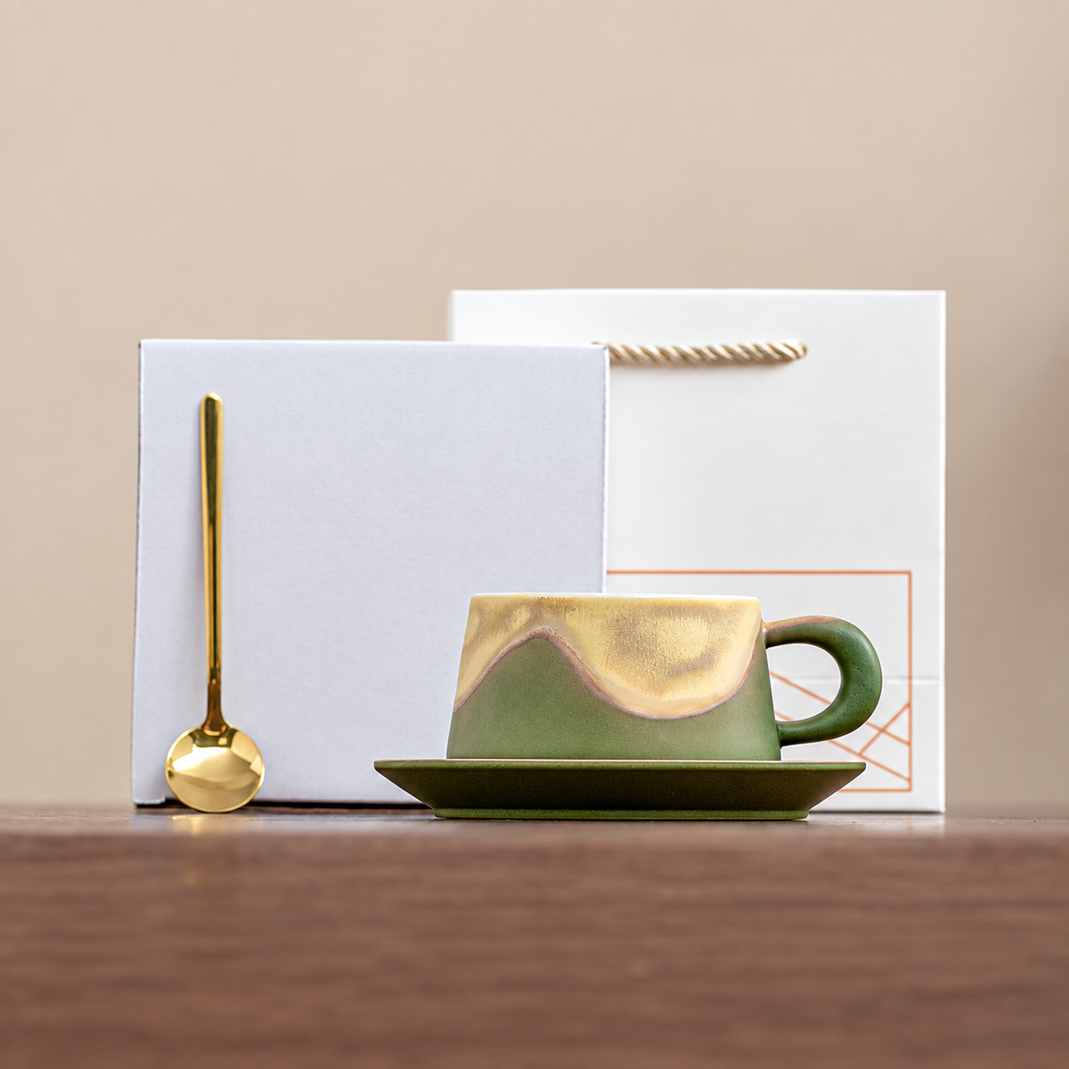 Green wave-glaze cup and saucer with gold-tone spoon, plain box and geometric gift bag