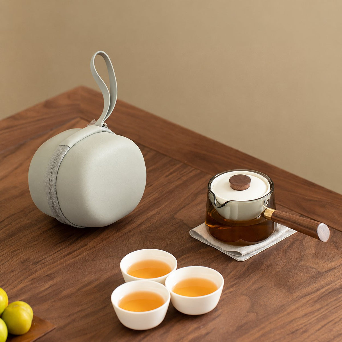 Smoked glass side-handle teapot with three ivory cups and round travel case