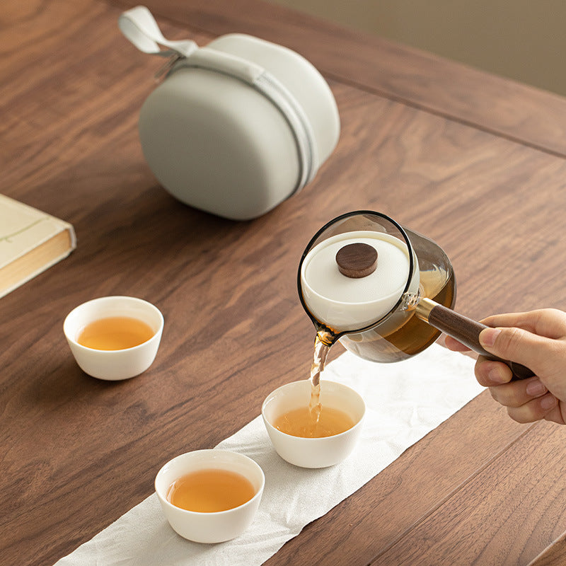 Tea poured from a rotating infuser teapot into three small cups