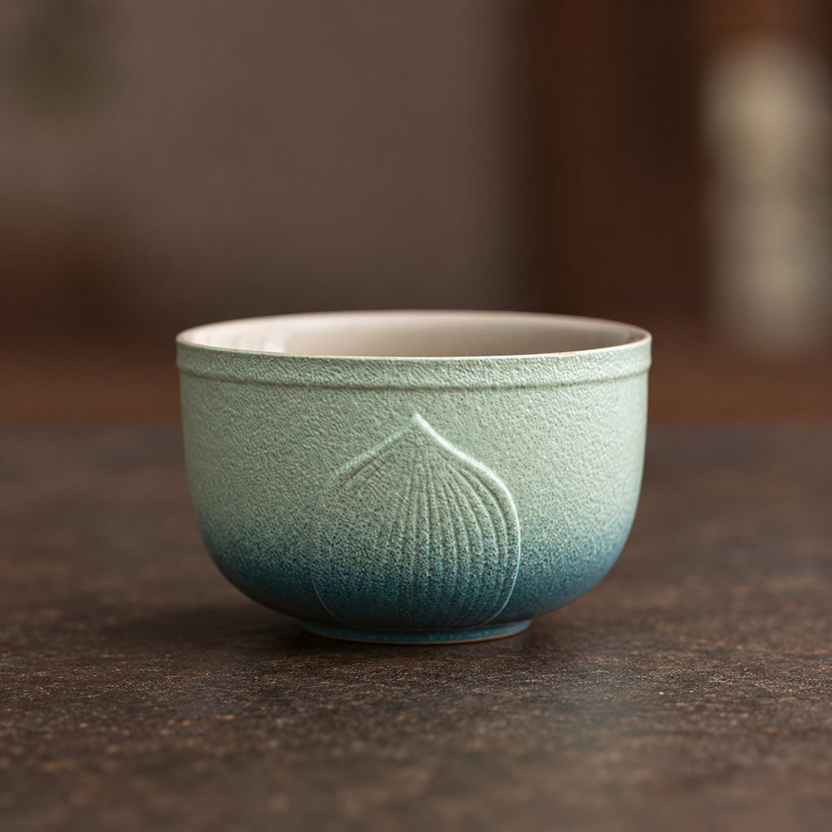 Raised lotus-petal detail on the larger gradient teacup