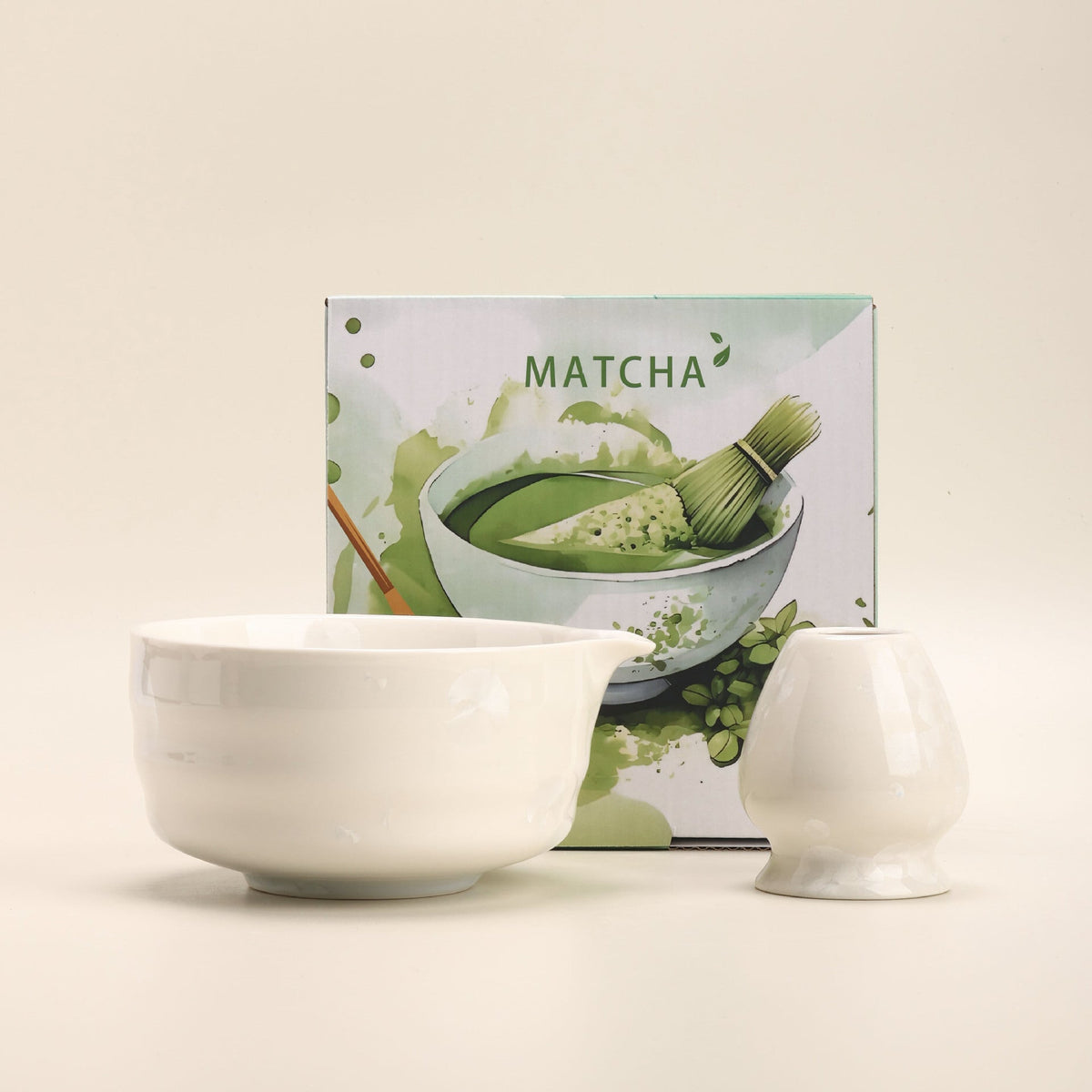 White crystalline-glaze ceramic matcha bowl and whisk holder beside their English MATCHA box