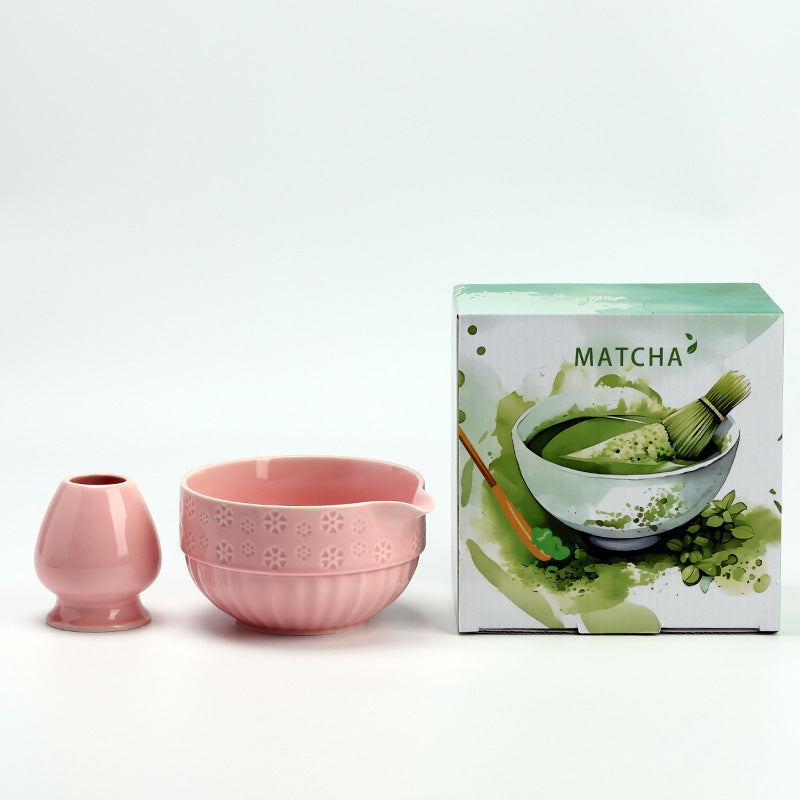 Pink embossed-flower matcha bowl and whisk holder with the illustrated MATCHA carton
