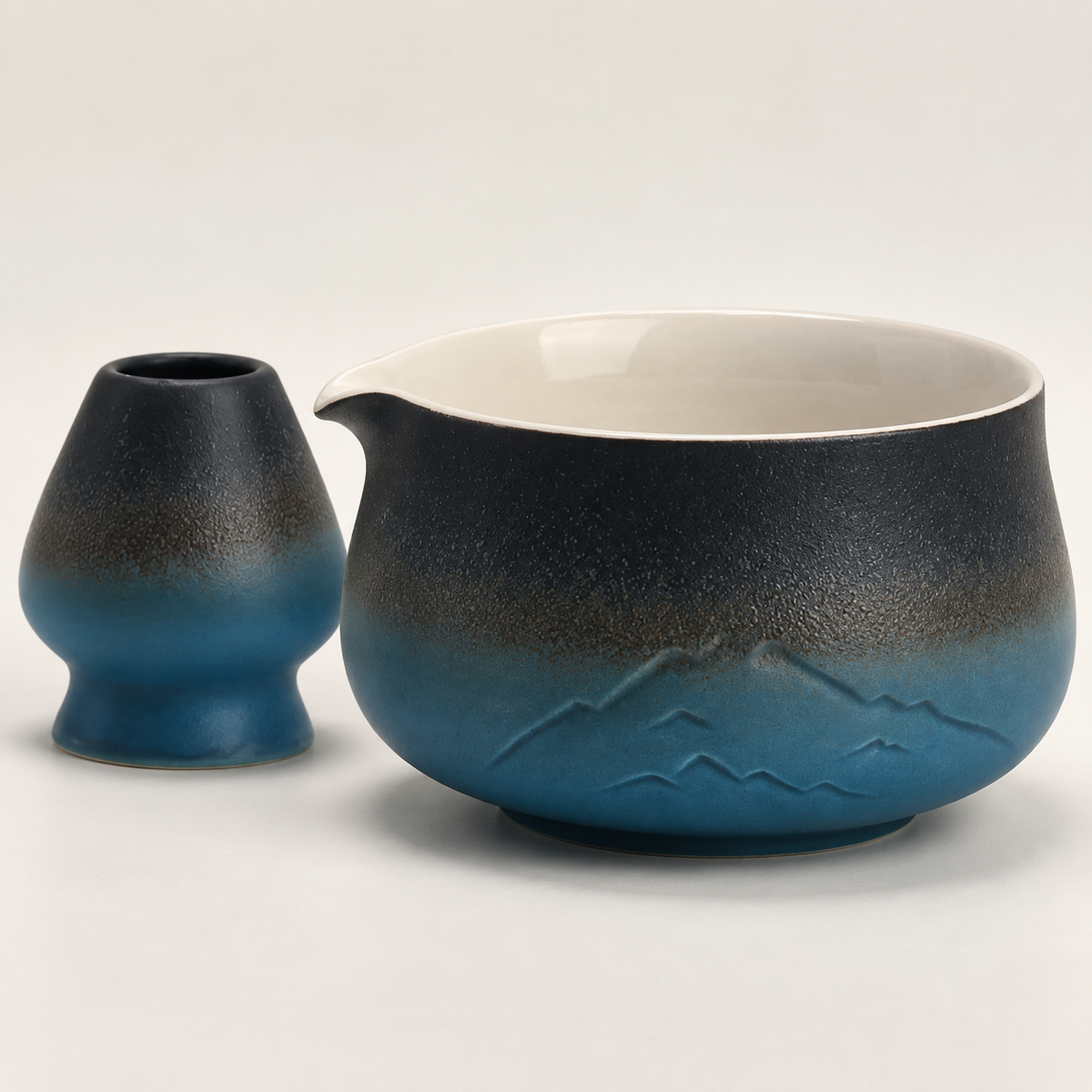 Close view of the black and blue mountain-relief matcha bowl and coordinating whisk holder